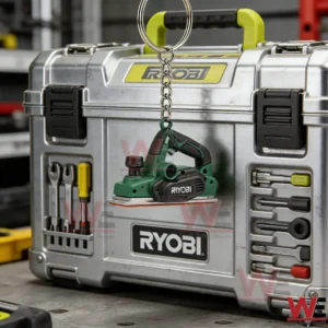 Mini Ryobi sander keychain hanging from a metal ring in front of a Ryobi toolbox inside a workshop!