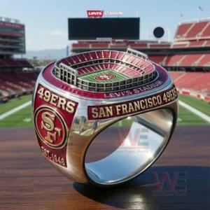 Close up of a San Francisco 49ers ring with a miniature Levi Stadium top red and gold team graphics and San Francisco 49ers lettering displayed in front of Levi Stadium!