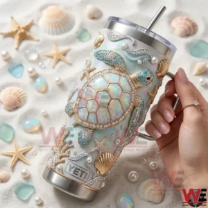 Hand holding sea turtle themed Yeti tumbler with shells and beach decor!