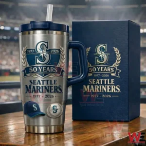 Silver and navy Seattle Mariners fifty years anniversary insulated tumbler with handle and straw beside a matching gift box in front of a blurred baseball stadium!