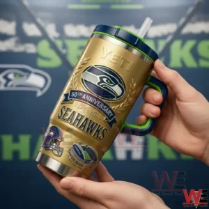 Seattle Seahawks 12th Man Go Hawks 50th Anniversary 1976-2026 Yeti Tumbler 4 Hand holding a gold Seattle Seahawks fiftieth anniversary handled tumbler with navy lid green trim and straw in front of a Go Hawks team themed background!