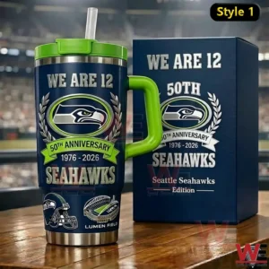Seattle Seahawks insulated tumbler with green handle lid and straw featuring anniversary branding and team graphics displayed on a table with a stadium background!