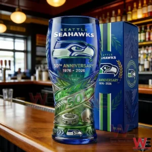 Seattle Seahawks fifty year anniversary glass with team logo and football themed details placed on a wooden bar surface!