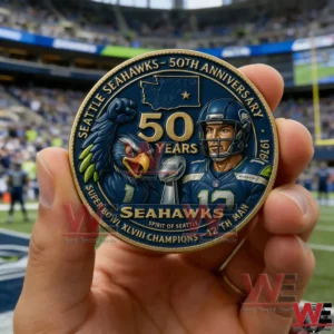 Hand holding a blue and gold Seattle Seahawks 50th anniversary commemorative coin with player and mascot artwork in front of a blurred stadium scene!
