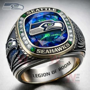 Black and gold Seattle Seahawks ring with a large blue green gemstone top Seahawks logo clear and green stone border Seattle Seahawks text on the rim engraved side details and Legion Of Boom engraving inside!