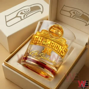 A Seattle Seahawks champions whiskey glass resting inside a high end gift box with gold accents and a clean elegant background!