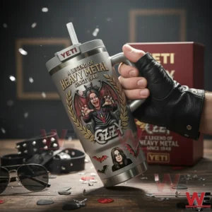 Hand holding a heavy metal themed tumbler on a table with stage accessories in a dark studio setting!