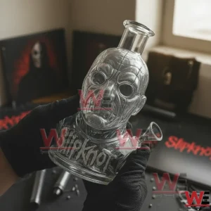 Slipknot Band Shaped Bong 5 Close up of gloved hands holding a clear glass masked face water pipe with Slipknot logo and a side bowl attachment with Slipknot albums in the background!