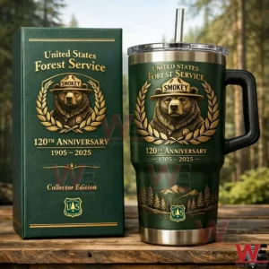 Dark green United States Forest Service Smokey anniversary insulated tumbler with handle and straw beside a matching collector edition box with a forest background!