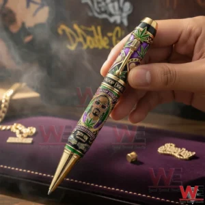 Hand holding a Snoop Dogg collector pen with gold details portrait artwork microphone design and leaf patterns on a velvet background!