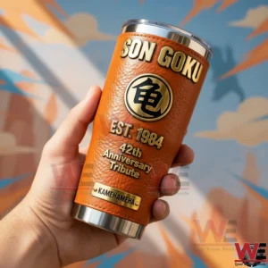 Hand holding an orange Son Goku insulated tumbler with anniversary tribute design in front of a themed background!