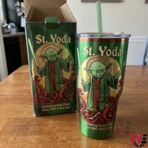 Green Saint Yoda themed insulated tumbler with matching box fantasy illustration and banishing bad vibes message on a wooden table!