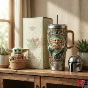 A Baby Yoda YETI tumbler and presentation box placed on a shelf with plants and themed decor creating a warm and charming display!