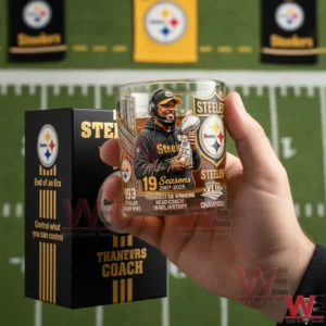 A hand holding a Steelers commemorative whiskey glass decorated with a coach portrait championship trophy team colors and milestone achievements!