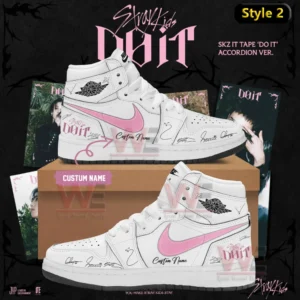 White high top Air Jordan one sneaker with pink swoosh do it themed signature markings and custom name displayed on a shoebox with Stray Kids album background