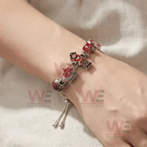 Adjustable charm bracelet on a wrist with Tampa Bay Buccaneers themed charms including helmet pirate ship pirate figure flag and number twelve jersey in red and silver.