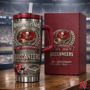 Stainless Tampa Bay Buccaneers 50th anniversary handled tumbler with straw beside a matching burgundy gift box on a wooden table in a stadium!
