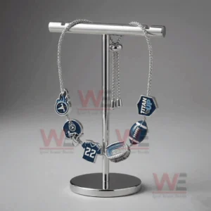 Silver adjustable charm bracelet with Tennessee Titans logo helmet number twenty two stadium football and Titan Up charms hanging on a metal display stand.