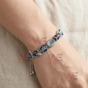 Silver adjustable charm bracelet worn on a wrist with Tennessee Titans logo helmet number twenty two stadium football and Titan Up charms plus an adjustable sliding clasp.