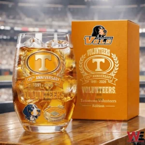 Tennessee Volunteers anniversary whiskey glass with ice and amber liquid placed next to an orange branded gift box!