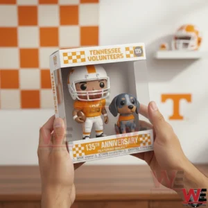A person holding a Tennessee Volunteers anniversary collectible figure box showing a football player and dog mascot inside with a checkerboard themed backdrop!