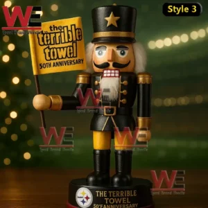 Wooden nutcracker figure in black and gold holding a Terrible Towel fiftieth anniversary flag on a base with Steelers branding and warm bokeh lights.
