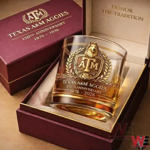 A Texas AM Aggies 150th anniversary whiskey glass in a maroon gift box with gold crest artwork and 1876 2026 commemorative text on a luxury presentation display