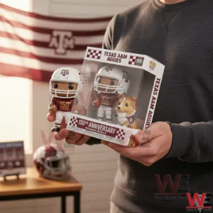 Hands holding a Texas AM Aggies one hundred fifty anniversary figure box containing a football player and the Reveille mascot in a room with team decor.