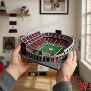 Texas A&M Aggies Aggie Stadium 150th Anniversary Building Blocks Set 5 Hands holding a Texas A and M building block stadium model with maroon seating and a green field in a bright room with team themed decor behind!