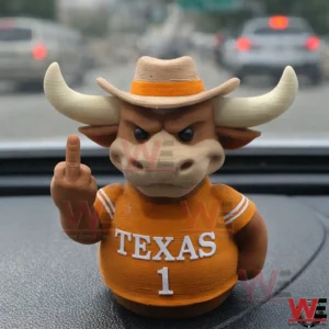 Close up of a small bull figure with horns wearing a cowboy hat and an orange Texas number one shirt making a rude hand gesture on a car dashboard with blurred traffic in the background.