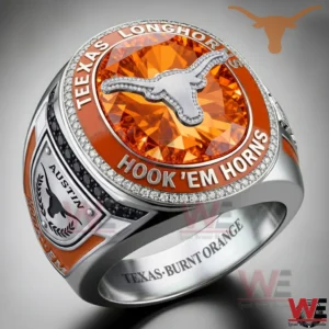 A Texas Longhorns championship style ring with a round face showing a silver longhorn logo on a burnt orange gemstone background surrounded by diamond like stones with TEXAS LONGHORNS and HOOK EM HORNS text plus Austin side details and an engraved interior message!