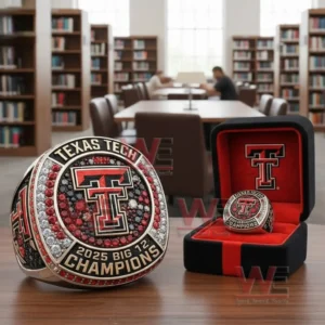 Texas Tech 2025 Big 12 Champions ring with a double T emblem and red black and clear stones displayed beside a black and red presentation box on a table in a library setting!