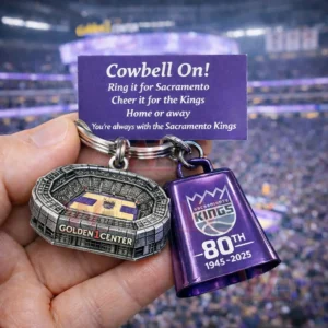 Hand holding Sacramento Kings keychain with Golden 1 Center stadium charm and purple 80th anniversary cowbell charm.