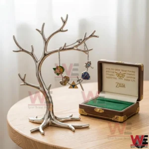 Zelda charm bracelet hanging on a metal stand with themed charms displayed next to an open wooden box with green velvet lining.