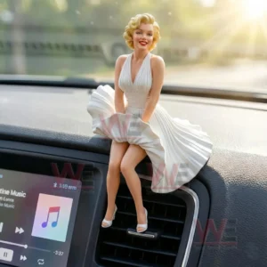 Blonde woman figurine in a flowing white dress and heels sitting on a car dashboard above an air vent with warm sunlight and a blurred outdoor background!