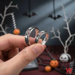 Hand holding matching gothic rings with skull details and sparkling stones in a themed setting!