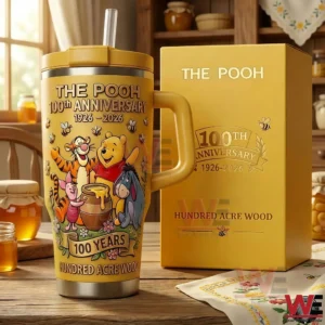 The Pooh 100th Anniversary tumbler with handle and straw next to a matching yellow gift box featuring classic characters honey themed artwork and anniversary text in a cozy kitchen background!