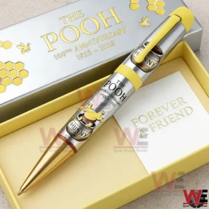 Silver and gold The Pooh anniversary pen inside an open yellow gift box with honeycomb details and one hundredth anniversary 1925 to 2025 text!