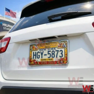 The Pooh 100th Anniversary Car License Plate Frame 4 Rear of a white vehicle with a New York license plate framed by Winnie the Pooh themed anniversary artwork near a stadium!
