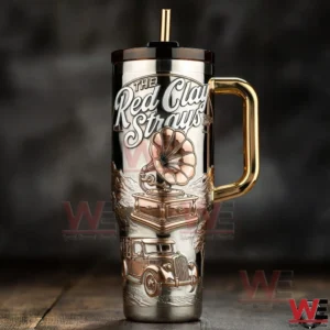 A tall insulated tumbler with The Red Clay Strays logo featuring a vintage gramophone illustration and classic country music inspired artwork displayed against a dark rustic background!