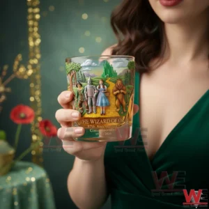 The Wizard of Oz 87th Anniversary Limited Edition 1939-2026 Whisky Glass 3 A woman holding a The Wizard of Oz eighty seven anniversary commemorative whiskey glass with classic character illustration in a magical studio setting!