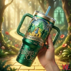 Hand holding a green fantasy metal tumbler with magical artwork of a storybook journey in a sunlit forest!