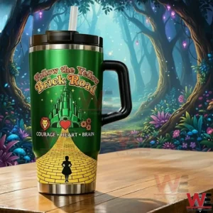 Green Follow the Yellow Brick Road tumbler with Emerald City artwork and courage heart brain icons on a wooden table with an enchanted forest background!