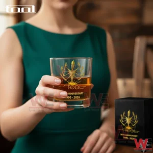 Tool Band Alex Grey Tool figure 1990-2026 Glass 4 A woman holding a TOOL anniversary whiskey glass filled with amber liquid emphasizing the detailed gold design and collectible quality!
