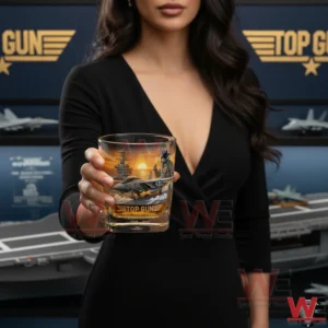 Top Gun 40th Anniversary Limited Edition 1986-2026 Whiskey Glass 3 A woman holding a Top Gun anniversary whiskey glass in a modern aviation display environment!