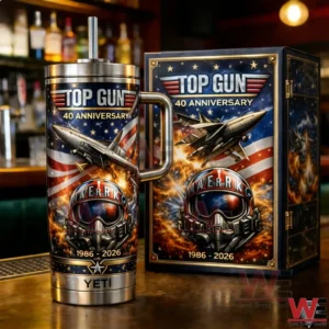 Top Gun Maverick 40Th Anniversary 1986-2026 Yeti Tumbler 5 Top Gun 40th Anniversary tumbler with handle and straw next to matching collector box showing fighter jet American flag flames Maverick helmet and 1986 2026 text on a bar counter!
