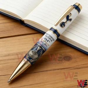 Tottenham Hotspur anniversary pen placed on a wooden table next to an open notebook!
