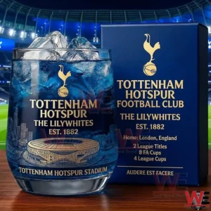 Tottenham Hotspur The Lilywhites Glory Glass 3 A Tottenham Hotspur glass with ice placed beside a branded box on a wooden surface with a football stadium backdrop!