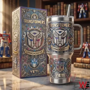 A stainless steel Transformers commemorative tumbler with elaborate engraved design shown next to a matching collectible box on a display surface!