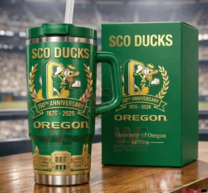Green handled tumbler with straw and matching collector box featuring Sco Ducks Oregon branding one hundred fifty th anniversary years one eight seven six to two zero two six and gold mascot laurel wreath and campus building artwork in a stadium background!